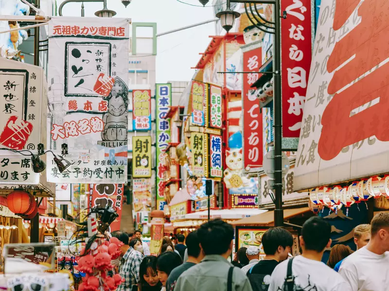 Brightly colored Japanese signs line a street in Osaka. 