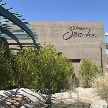 The entrance to a stone building with "The Spa at Séc-he" on its facade