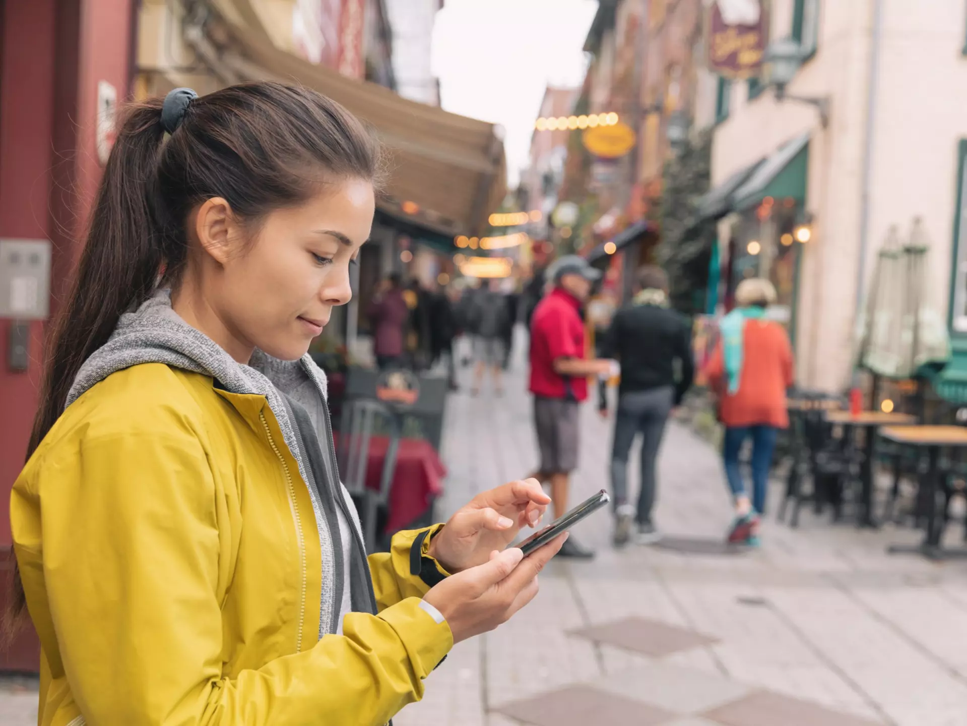 Woman using mobile phone app while walking in city street to find a store direction on map or order online at restaurant. Asian woman canadian city lifestyle.  License Type: media  Download Time: 2024-02-07T13:27:42.000Z  User: jennifercarey0150  Is Editorial: No  purchase_order: