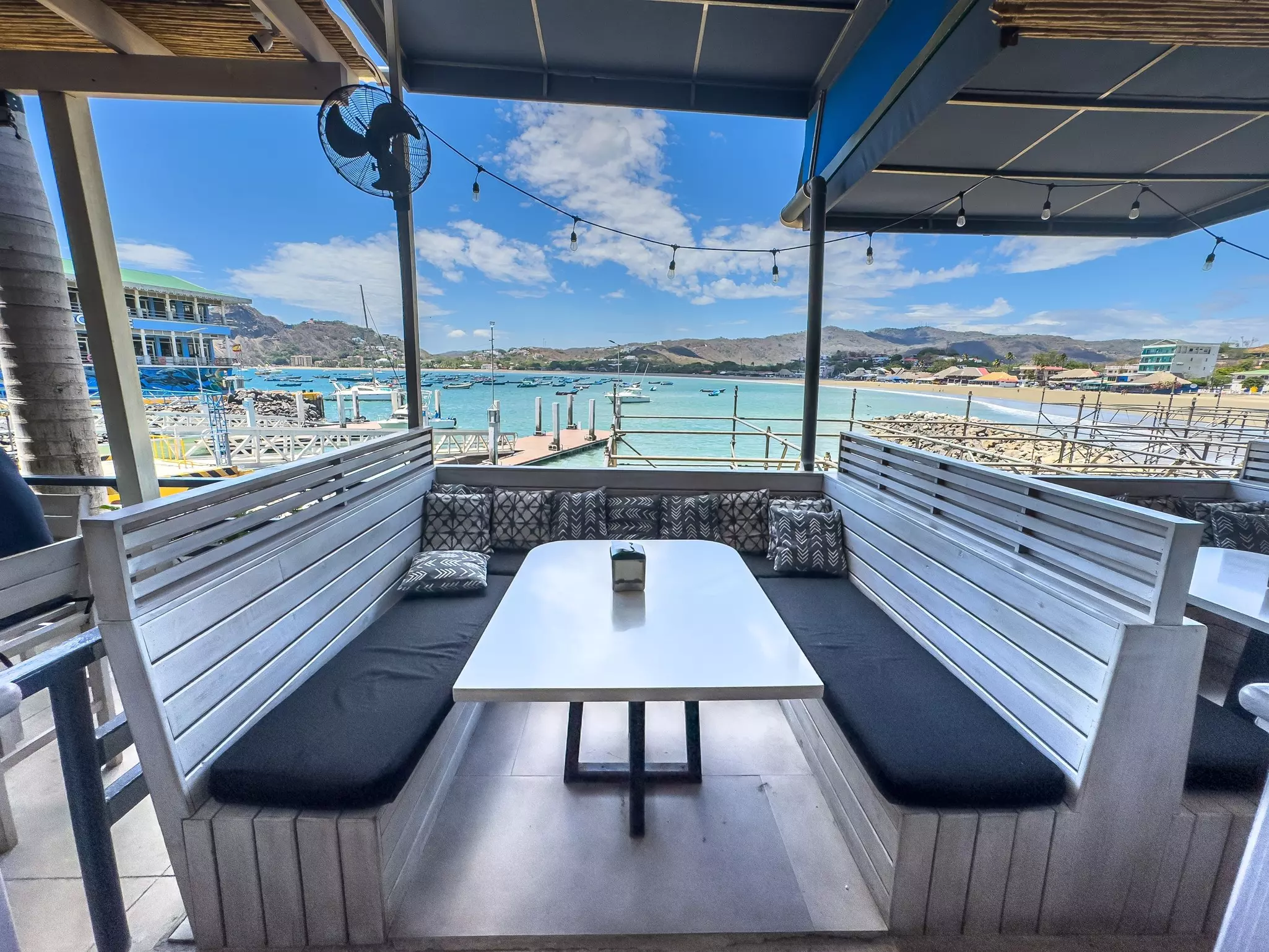 A booth in a restaurant looking out over the ocean and a small harbor.