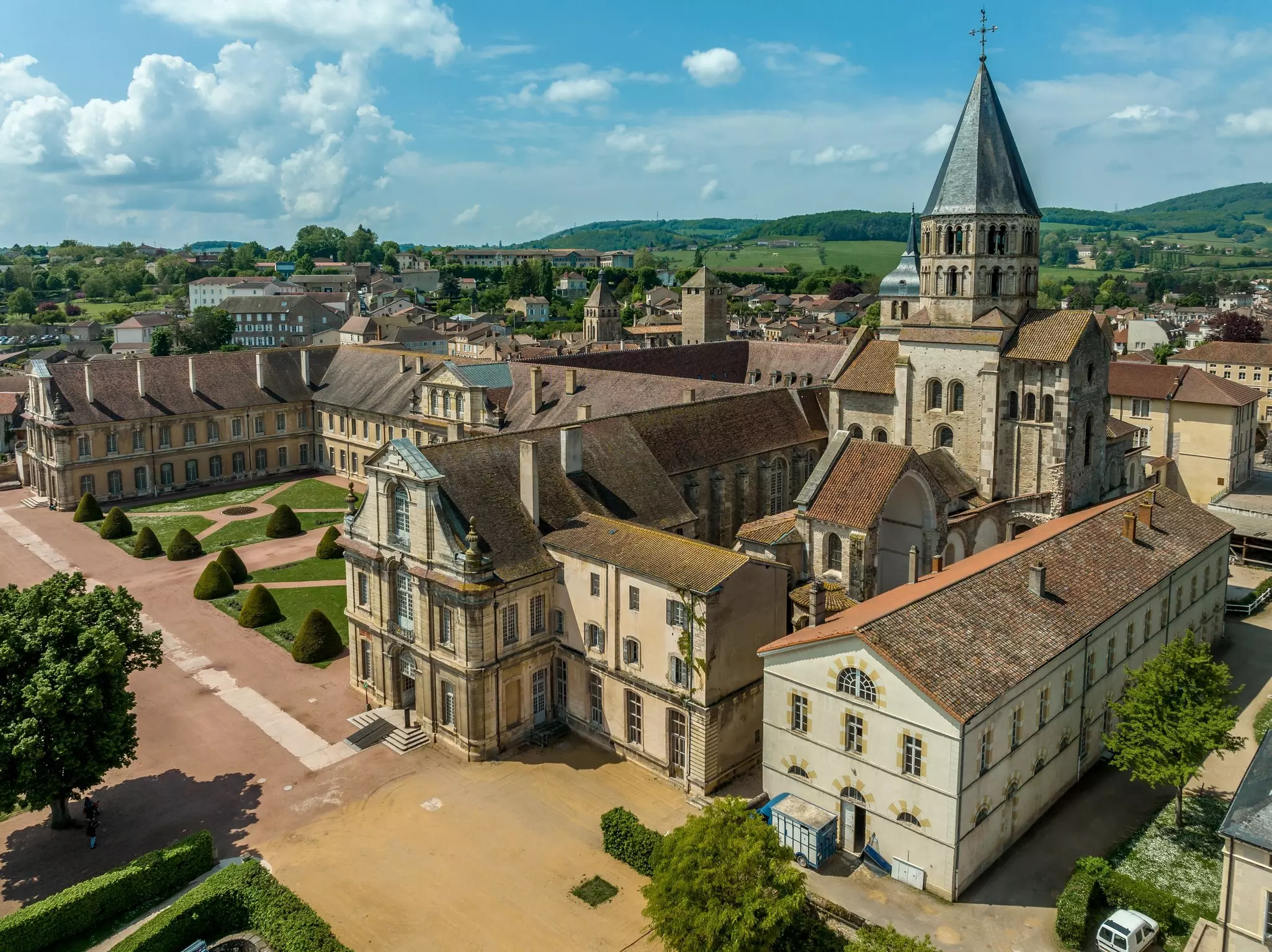 A large abbey with a round pointed tower and neat green lawns.