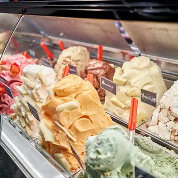 A counter of gelato in various colors and flavors in Rome, Italy.