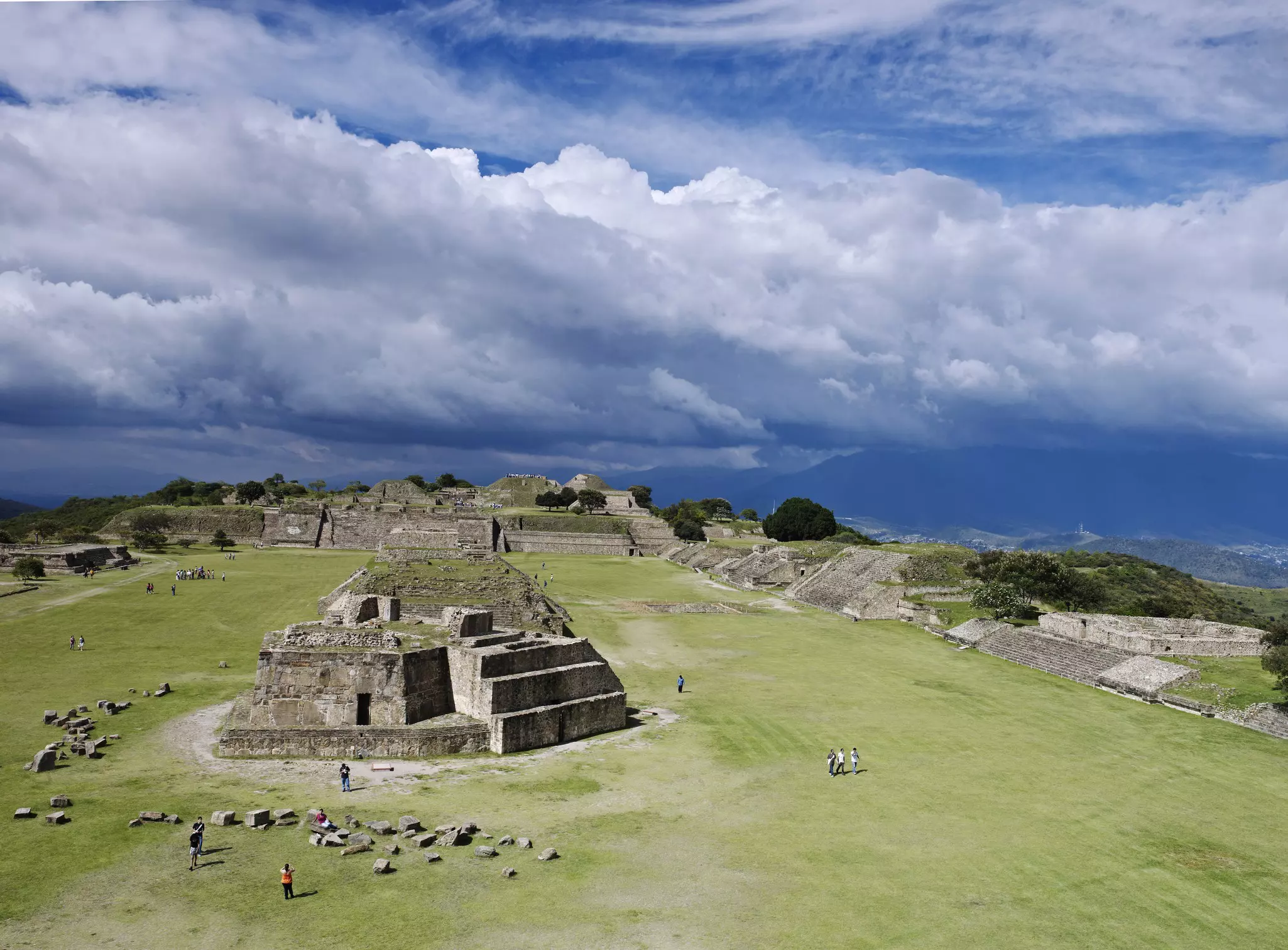 People visit an ancient pyramid and other structures in an archaeological site