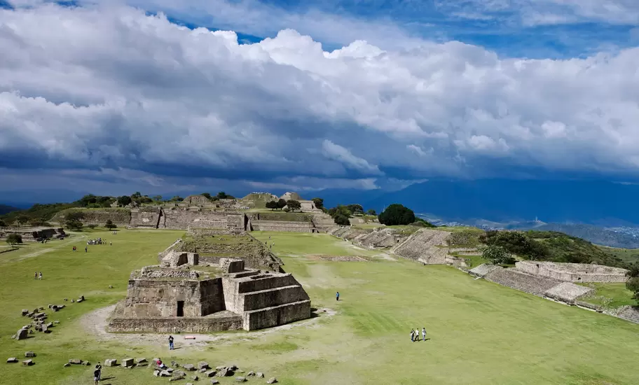 People visit an ancient pyramid and other structures in an archaeological site