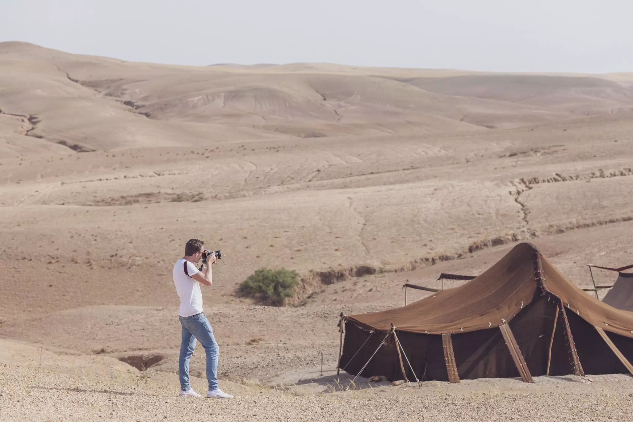 A man photographing tents in the Agafay Desert, Morocco