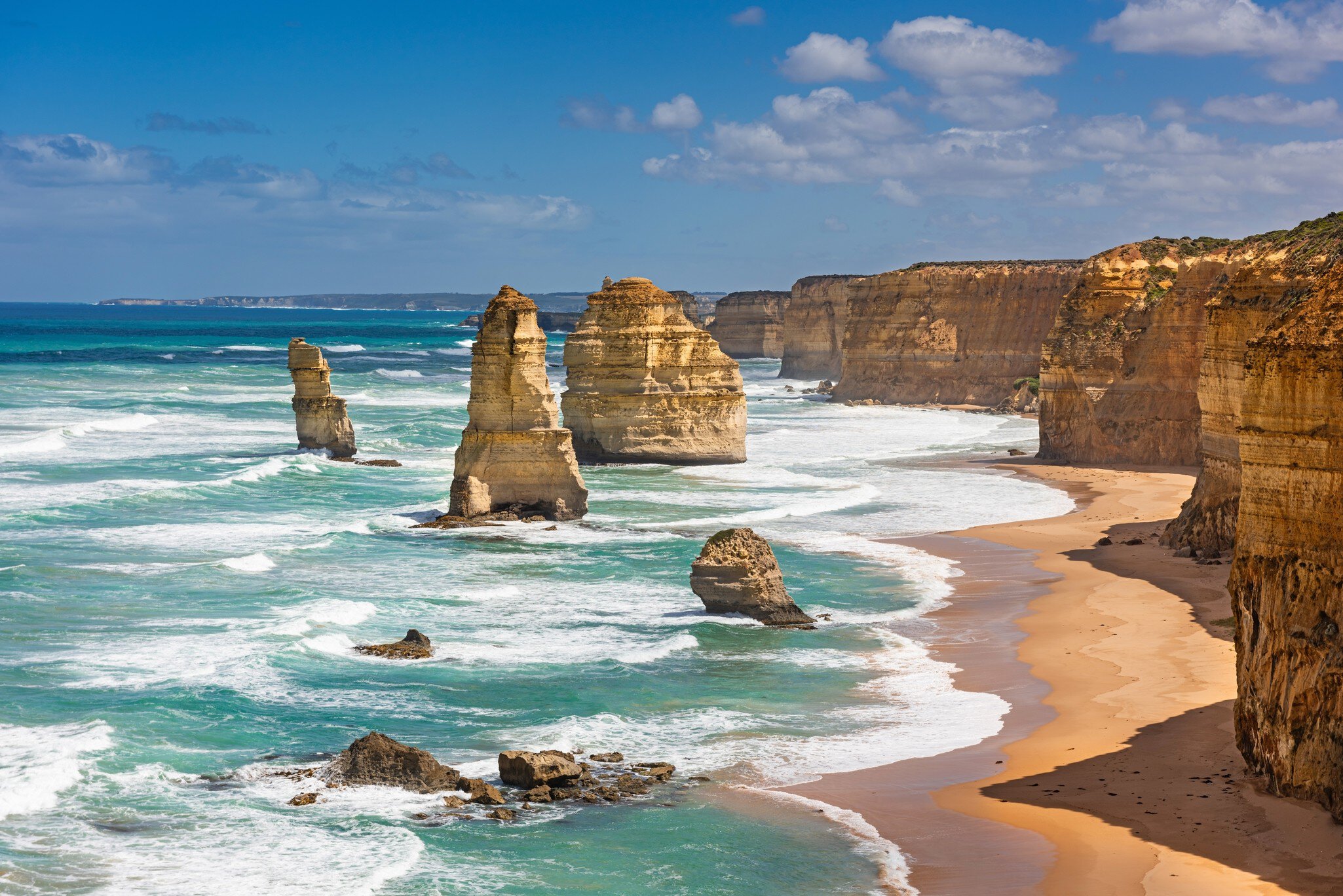 Limestone stacks standing in the surf below cliffs on the Victorian coast