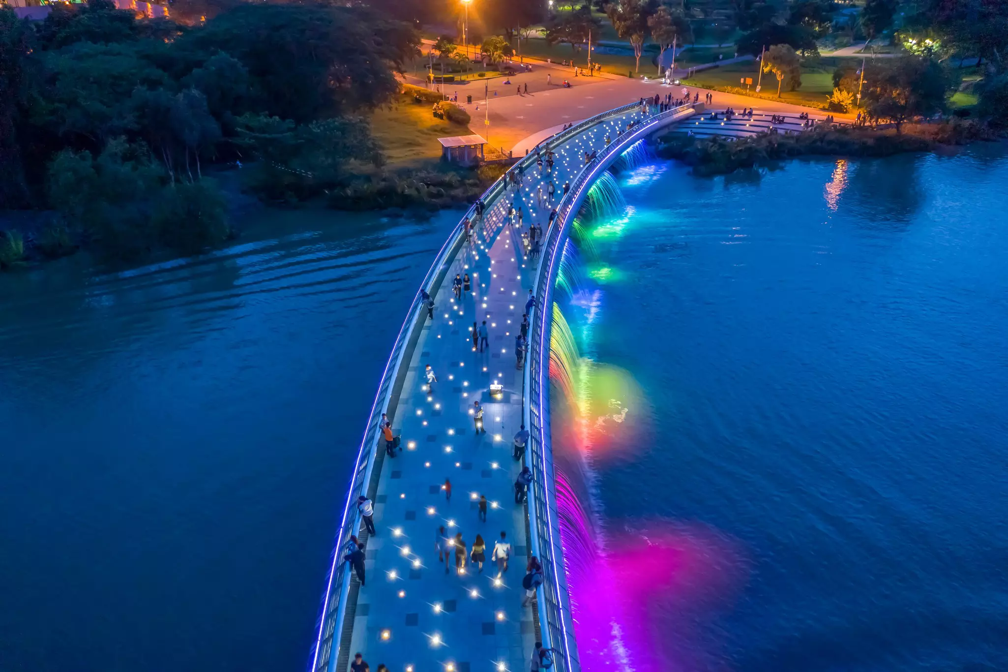 Starlight Bridge at night, with multicolored lights along the sides and white lights on the walking path.