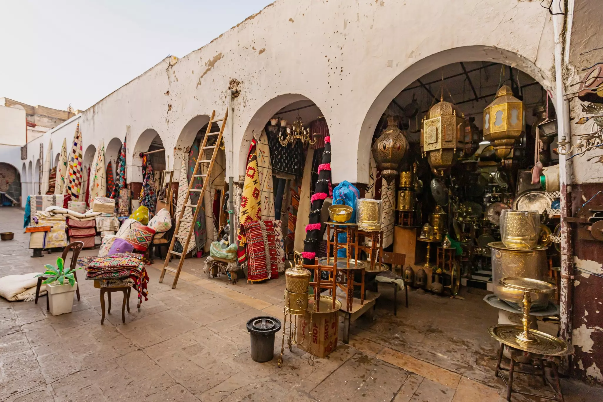 Lamps, carpets and other goods for sale under archways in Casablanca.