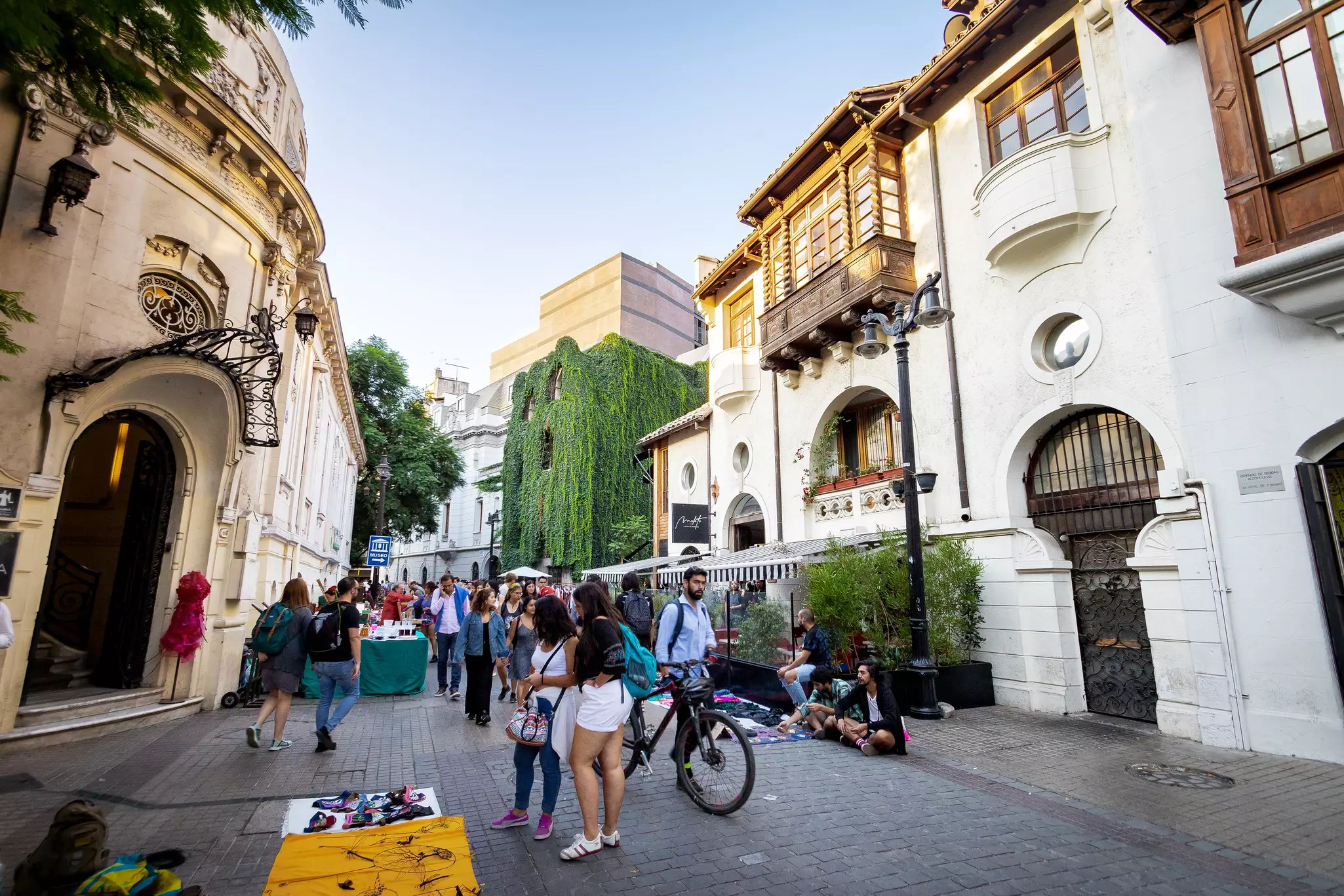 People stroll on a pedestrian street with historic houses in a city.