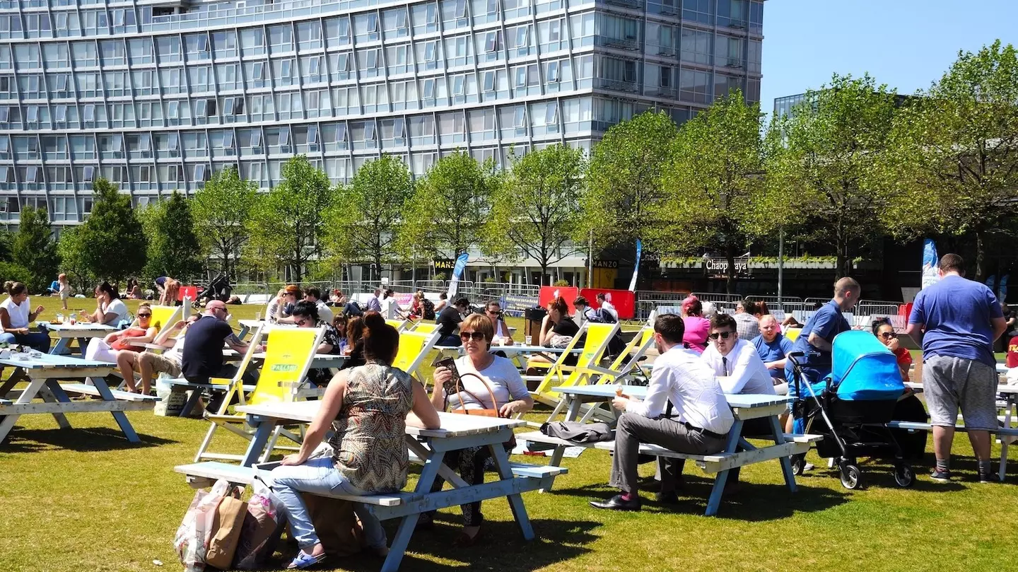 People relaxing at picnic benches in Chavasse Park in summer, Liverpool, Merseyside, England, United Kingdom, Western Europe