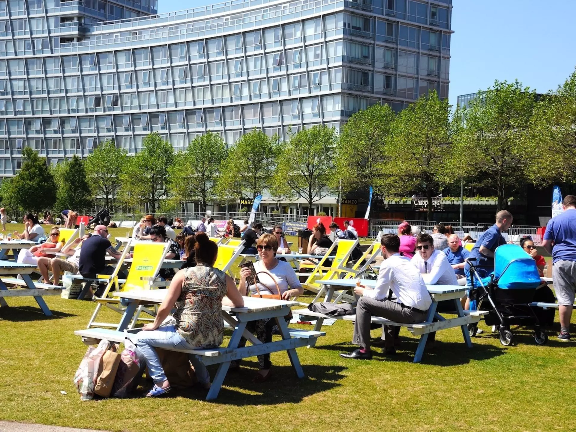 People relaxing at picnic benches in Chavasse Park in summer, Liverpool, Merseyside, England, United Kingdom, Western Europe