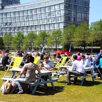 People relaxing at picnic benches in Chavasse Park in summer, Liverpool, Merseyside, England, United Kingdom, Western Europe
