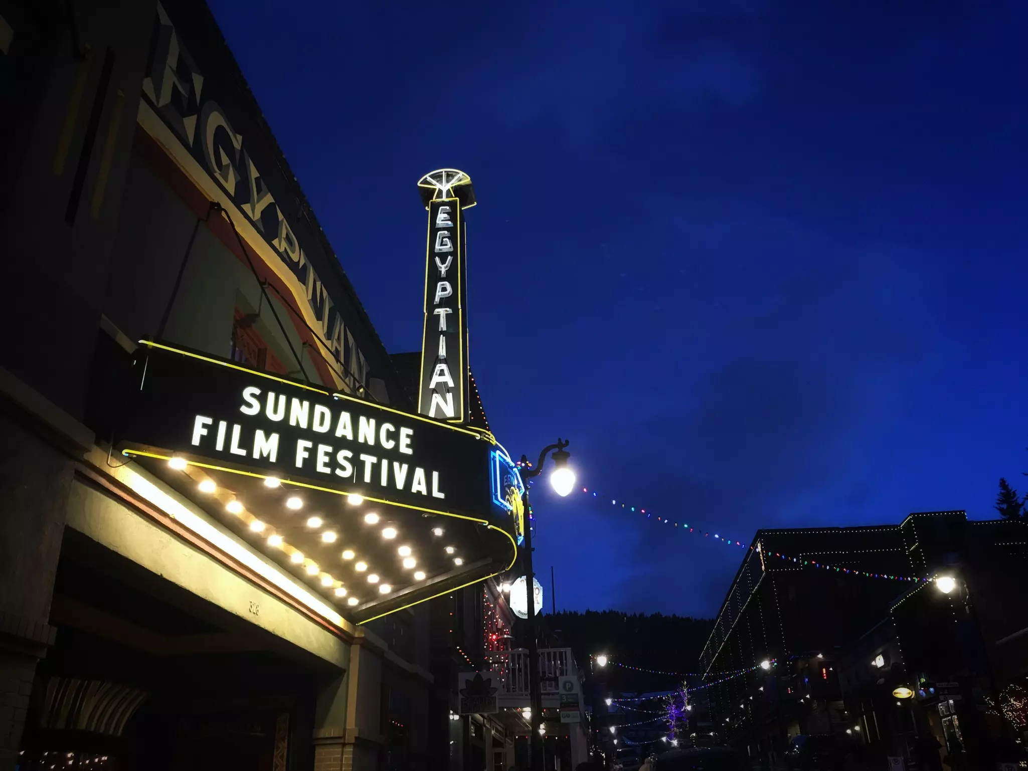 A lighted movie theater sign at night reading "Egyptian" and "Sundance Film Festival."
