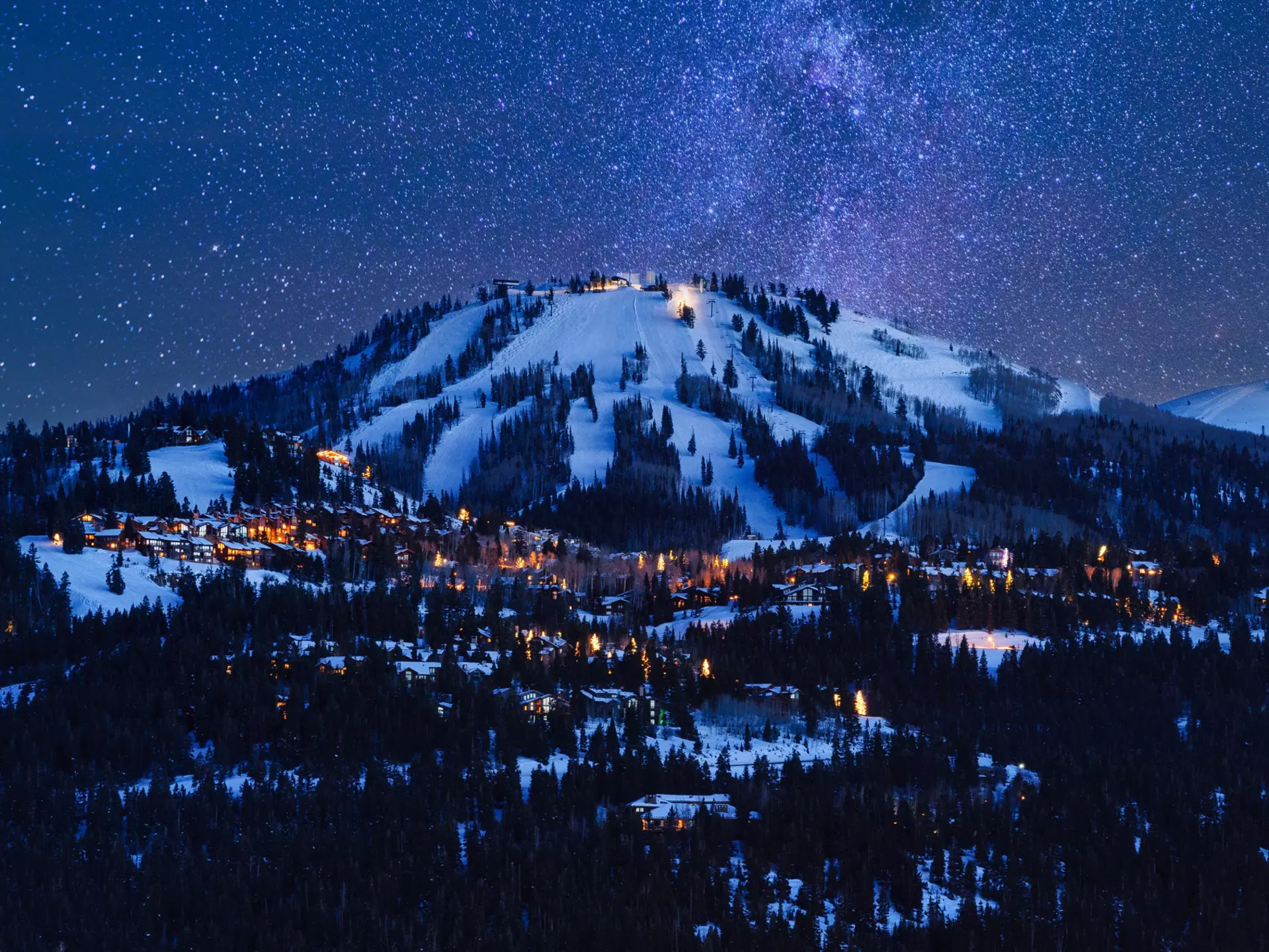 Deer Valley resort illuminated at dusk under a starry night sky © Adventure_Photo / Getty Images