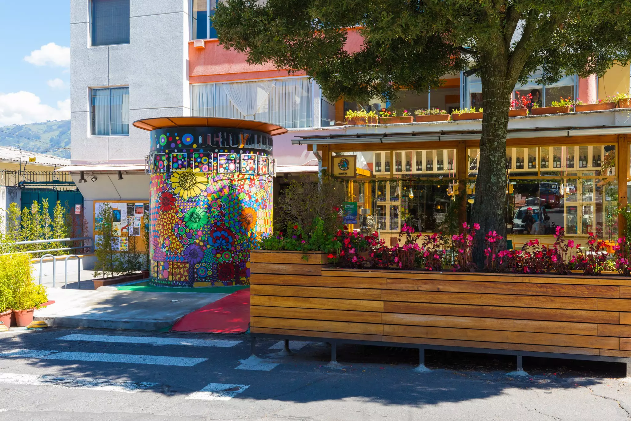 Outdoor seating, planters and other fixtures in a city neighborhood is painted with bright colors.