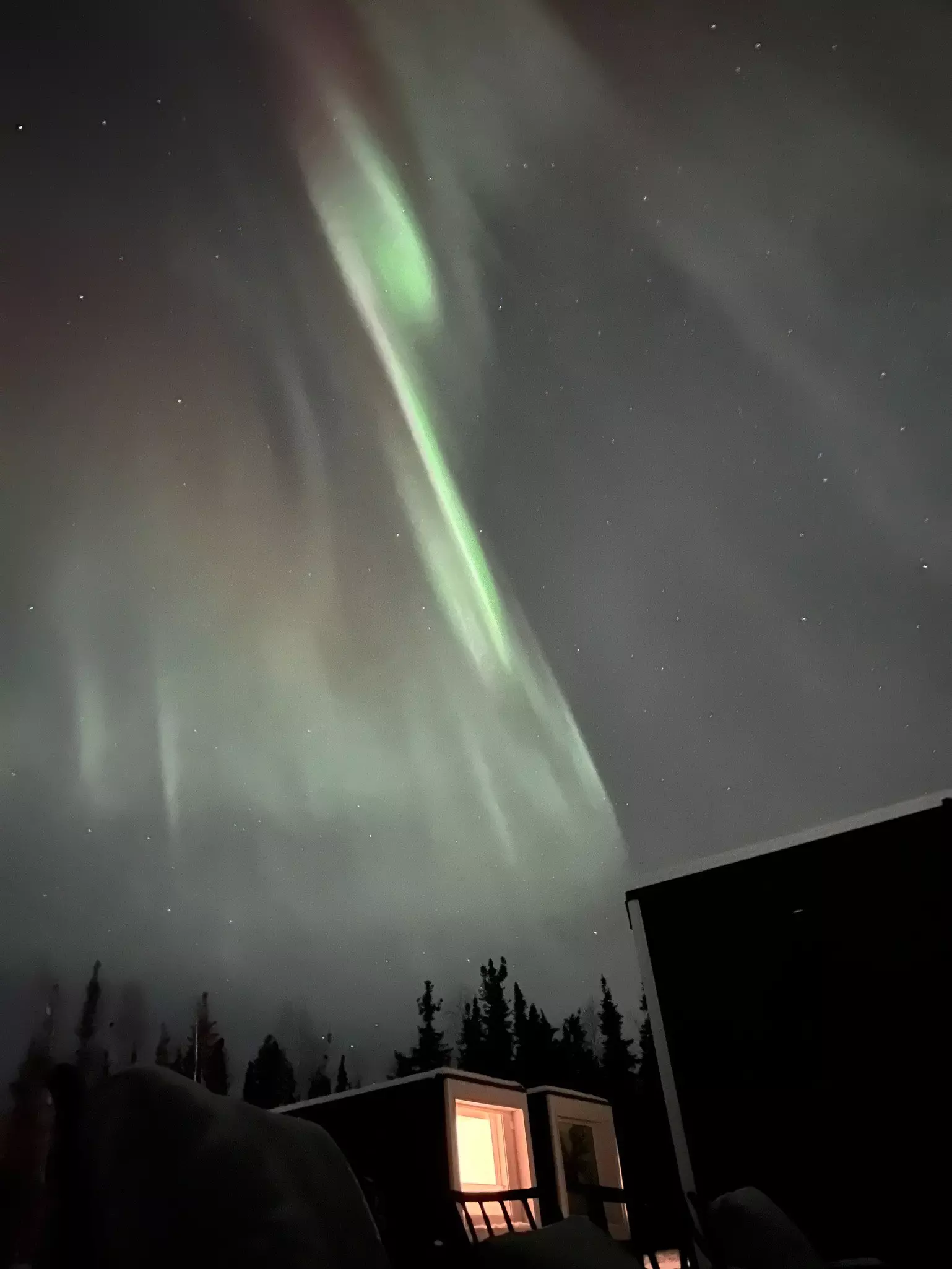 Wisps of aurora borealis light up a starry sky in Alaska.
