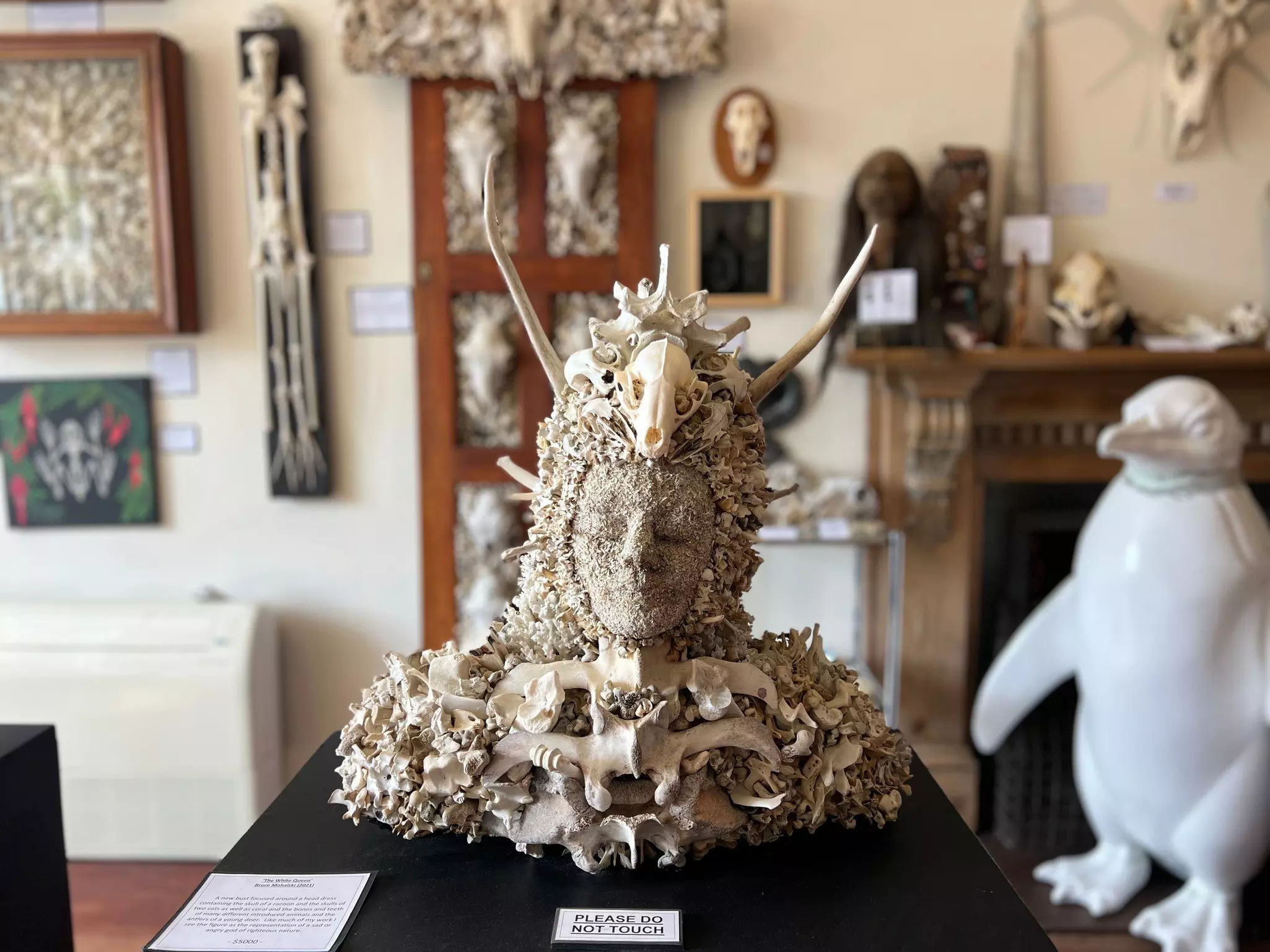 A figurative sculpture made out of pieces of bone and a small animal skull.