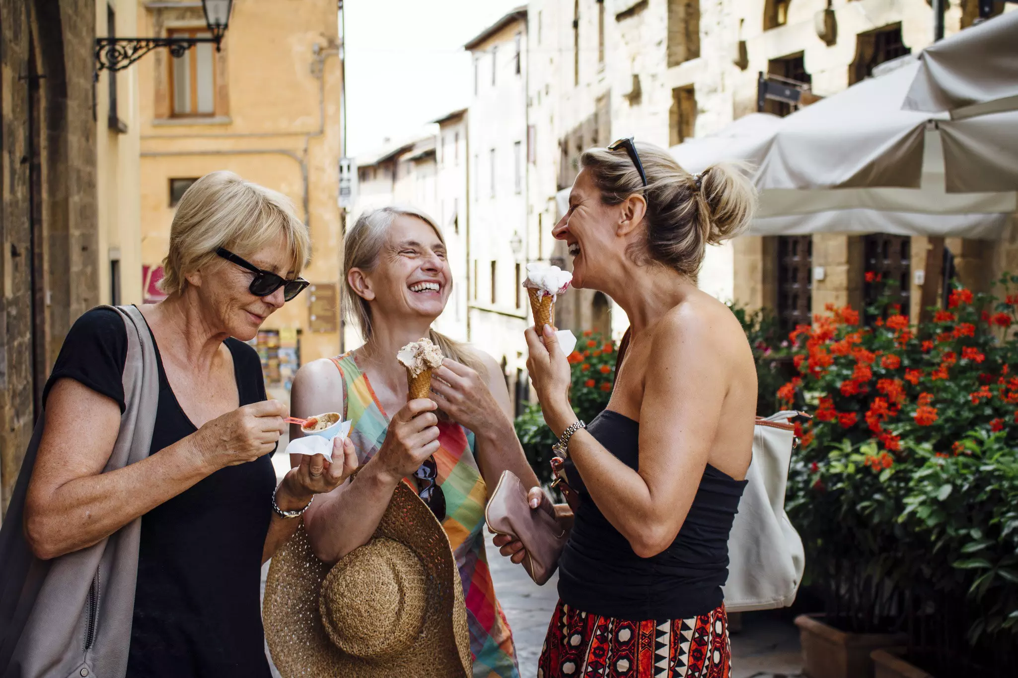 A group of three female friends eating ice cream in an Italian street