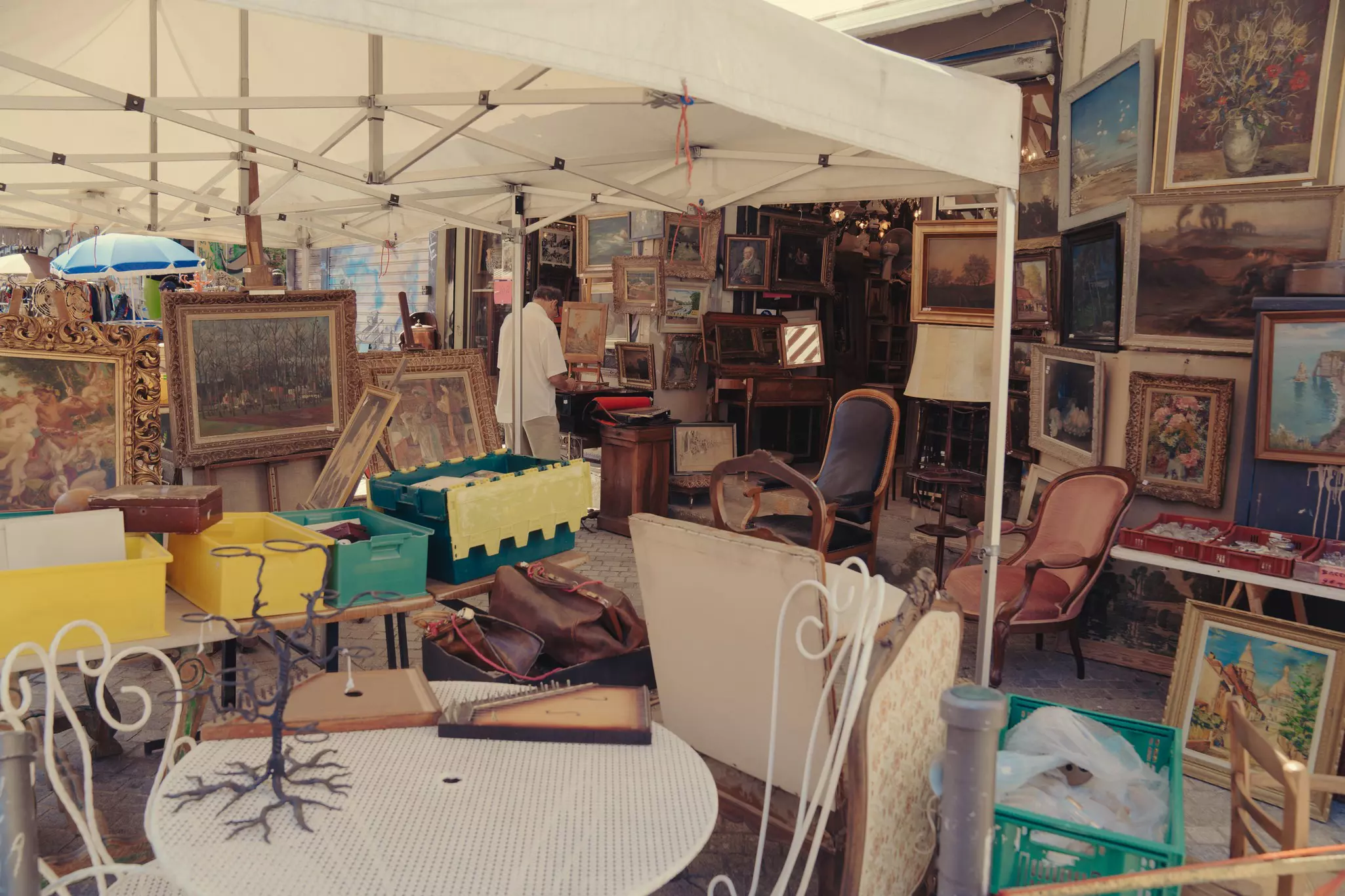 A market stall loaded with furniture and paintings