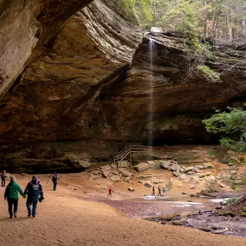 Visitors exploring Ash Cave in Hocking Hills State Park. arthurgphotography/Shutterstock