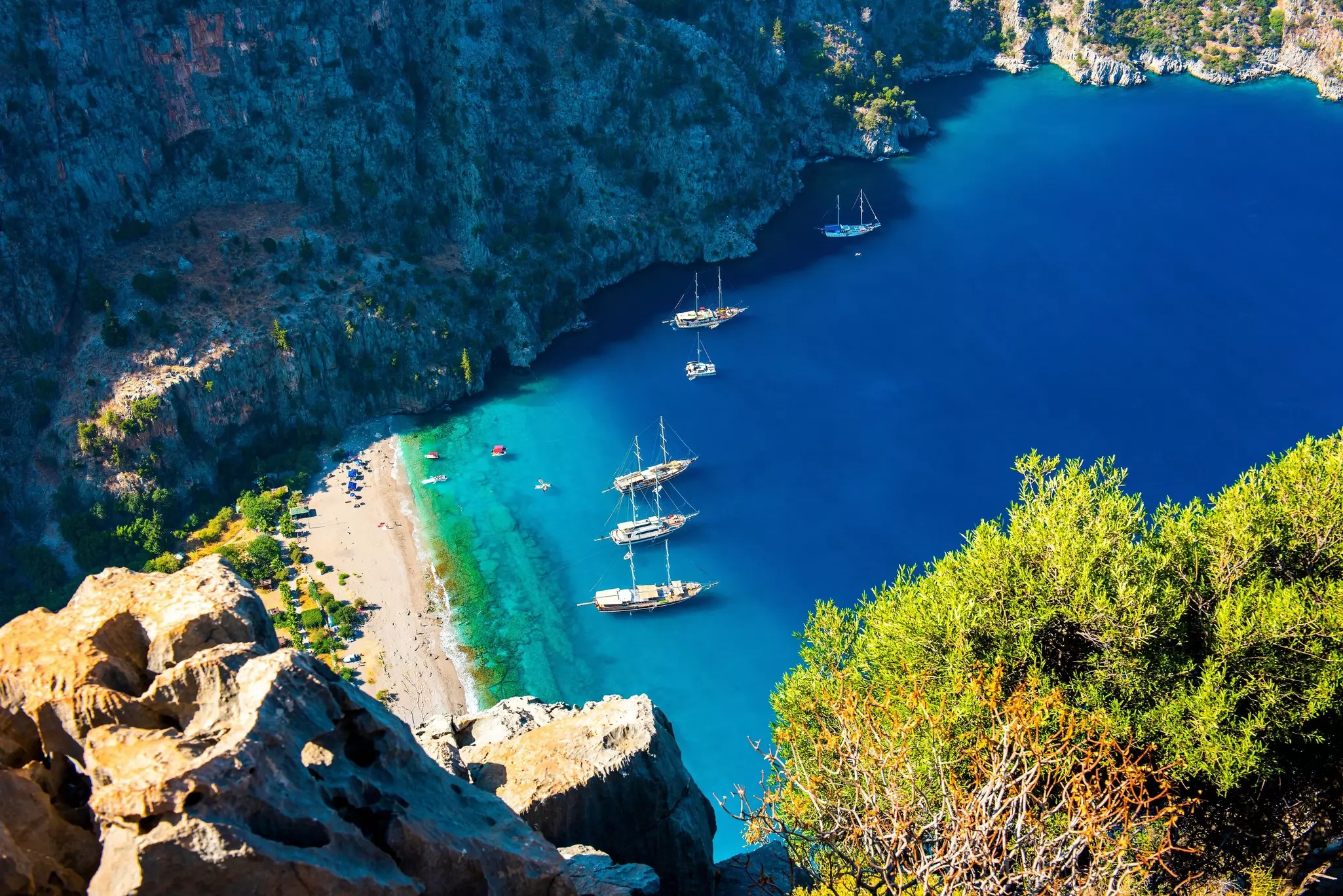Aerial view of crystal blue water and several boats in Turkey. 