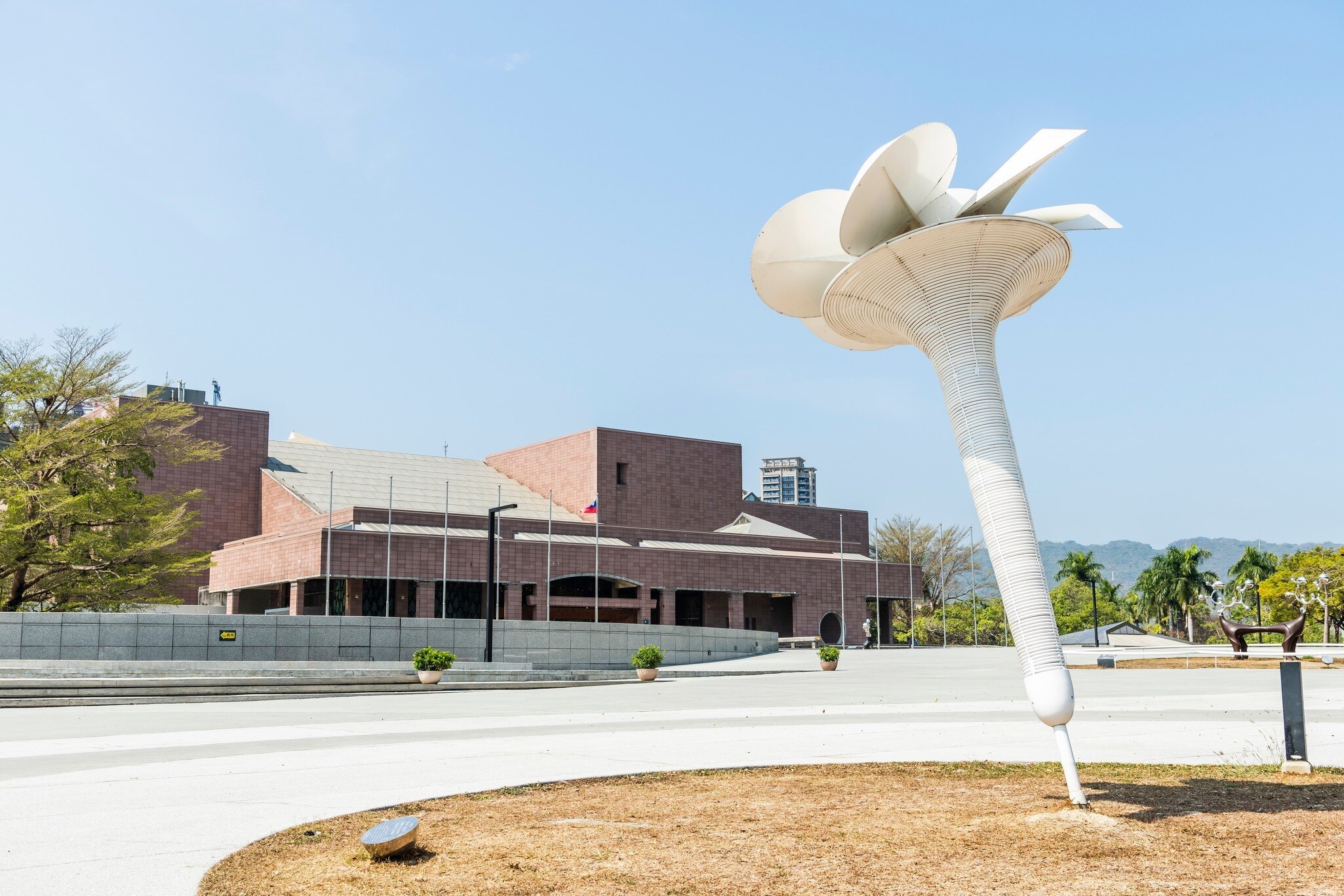 White flower sculpture in front of the brick building of the Kaohsiung Museum of Fine Arts in Kaohsiung, Taiwan.