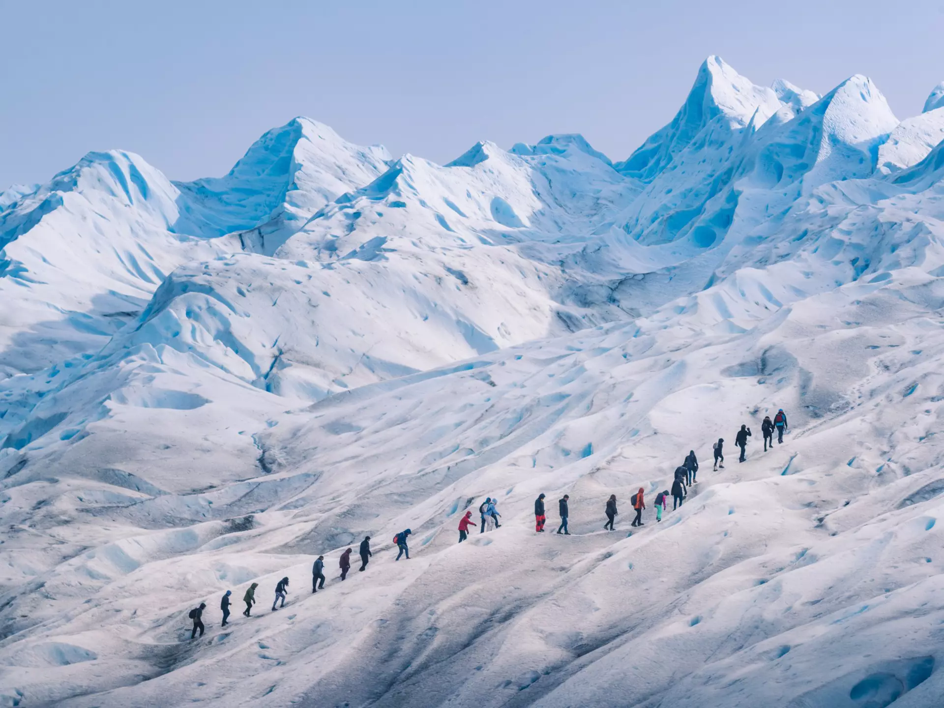 People hiking in a row on the ice of Perito Moreno glacier, Los Glaciares National Park