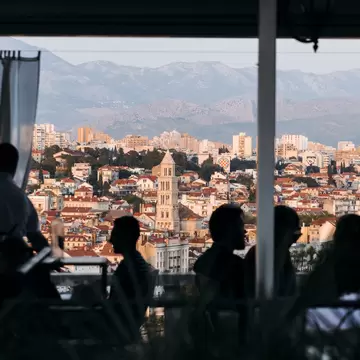 Diners silohuetted by the sunset, a view of Split at sunset from a restaurant at Marjan Hill