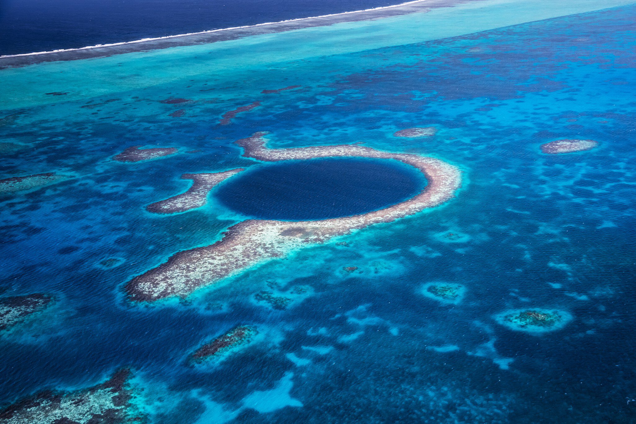 Aerial view down to the famous diving site and natural phenomenon the Blue Hole in the Lighthouse Reef, East of the Turneffe Atoll in Caribbean Sea, Belize, Central America.
510247581
Aerial View, Atoll, Backgrounds, Belize, Blue, Blue Hole, Caribbean, Caribbean Sea, Circle, Copy Space, Coral, Coral Colored, Famous Place, Lighthouse Reef, Natural Landmark, Natural Phenomenon, Nature, Photography, Postcard, Recreational Pursuit, Reef, Relaxation, Scuba Diving, Sea, Seascape, Sinkhole, Snorkeling, The Cayes, Tourism, Travel, Travel Destinations, Tropical Climate, Underwater Diving, Vacations, Water
