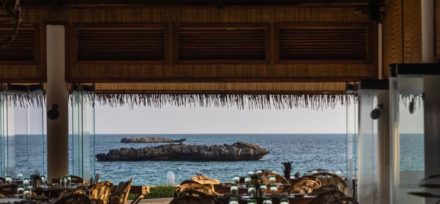 An empty restaurant; the far side is open to the water.