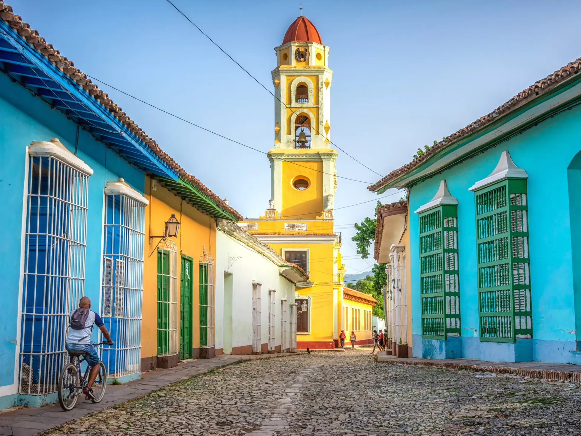 unrecognisable cuban man riding a bike  in the road to San Francisco de Asis church tower in Trinidad, Cuba
1330959778