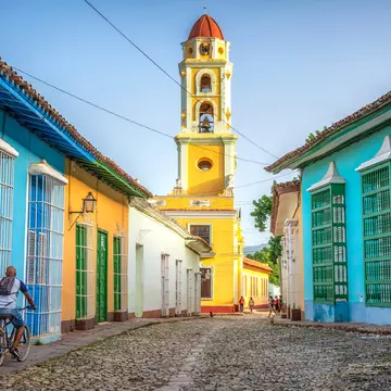 unrecognisable cuban man riding a bike  in the road to San Francisco de Asis church tower in Trinidad, Cuba
1330959778