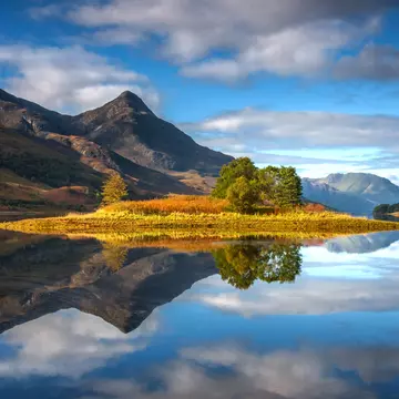 Reflections of the island in Loch Leven, Scotland, with the Pap of Glencoe in the middle distance.