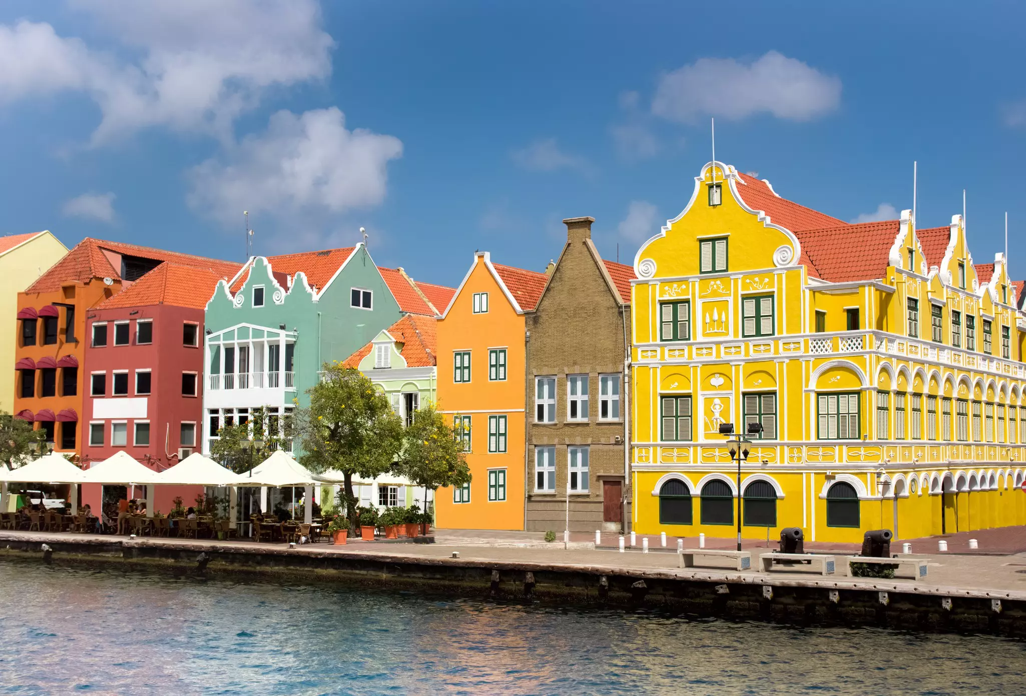 A harborfront lined with large pastel-colored buildings.