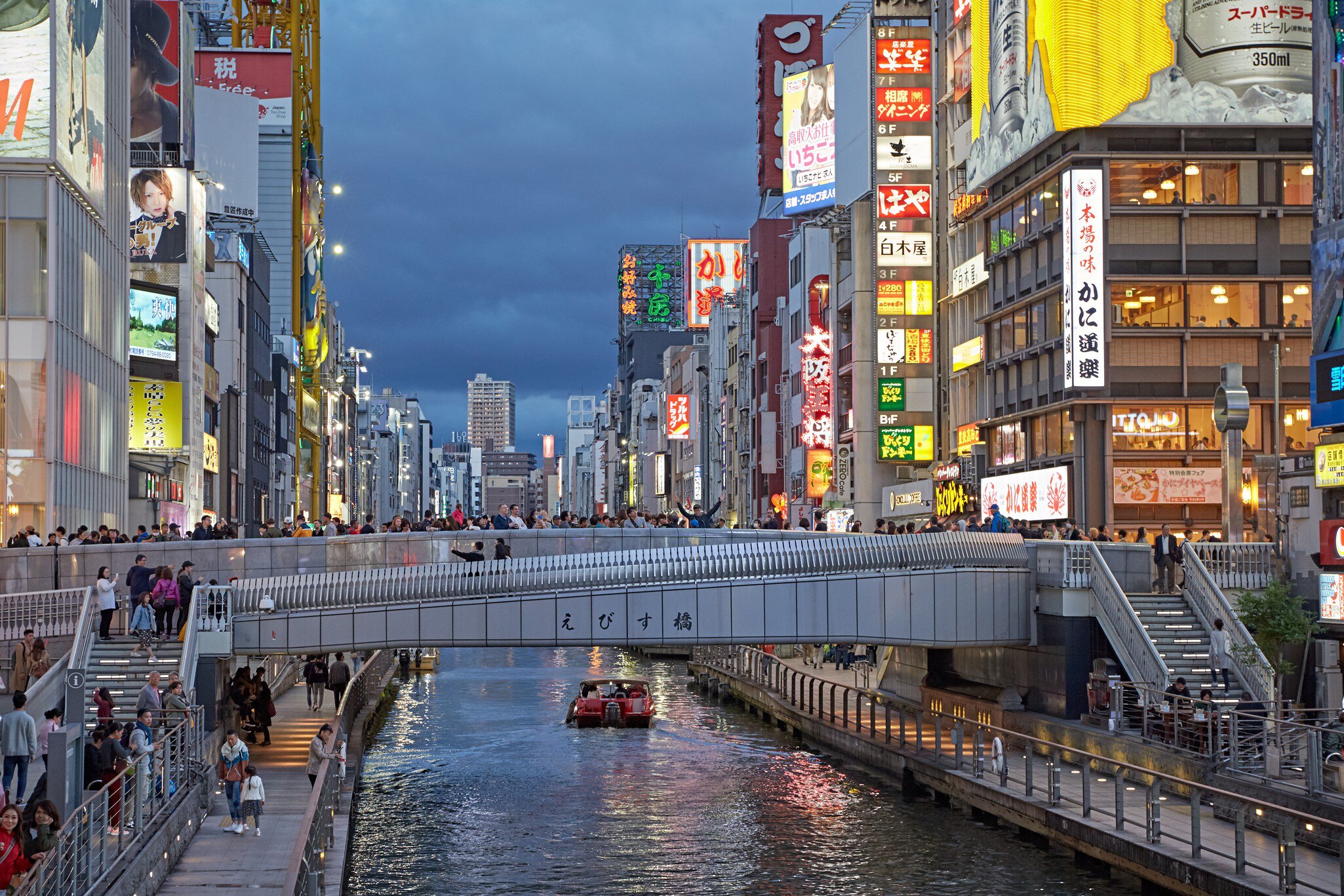 Osaka, Japan, April 2018. People crossing the Ebisu bridge on the Dontonbori canal at sunset., License Type: media, Download Time: 2026-05-28T21:03:25.000Z, User: LP_NZhan, Editorial: true, purchase_order: 65050 - Digital Destinations and Articles, job: App Content, client: Lonely Planet, other: Nadine Zhan