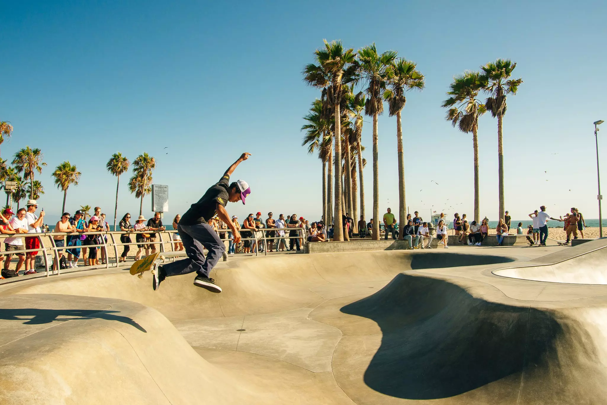 Pedestrians and cyclists on pathways next to Venice Beach in LA. 