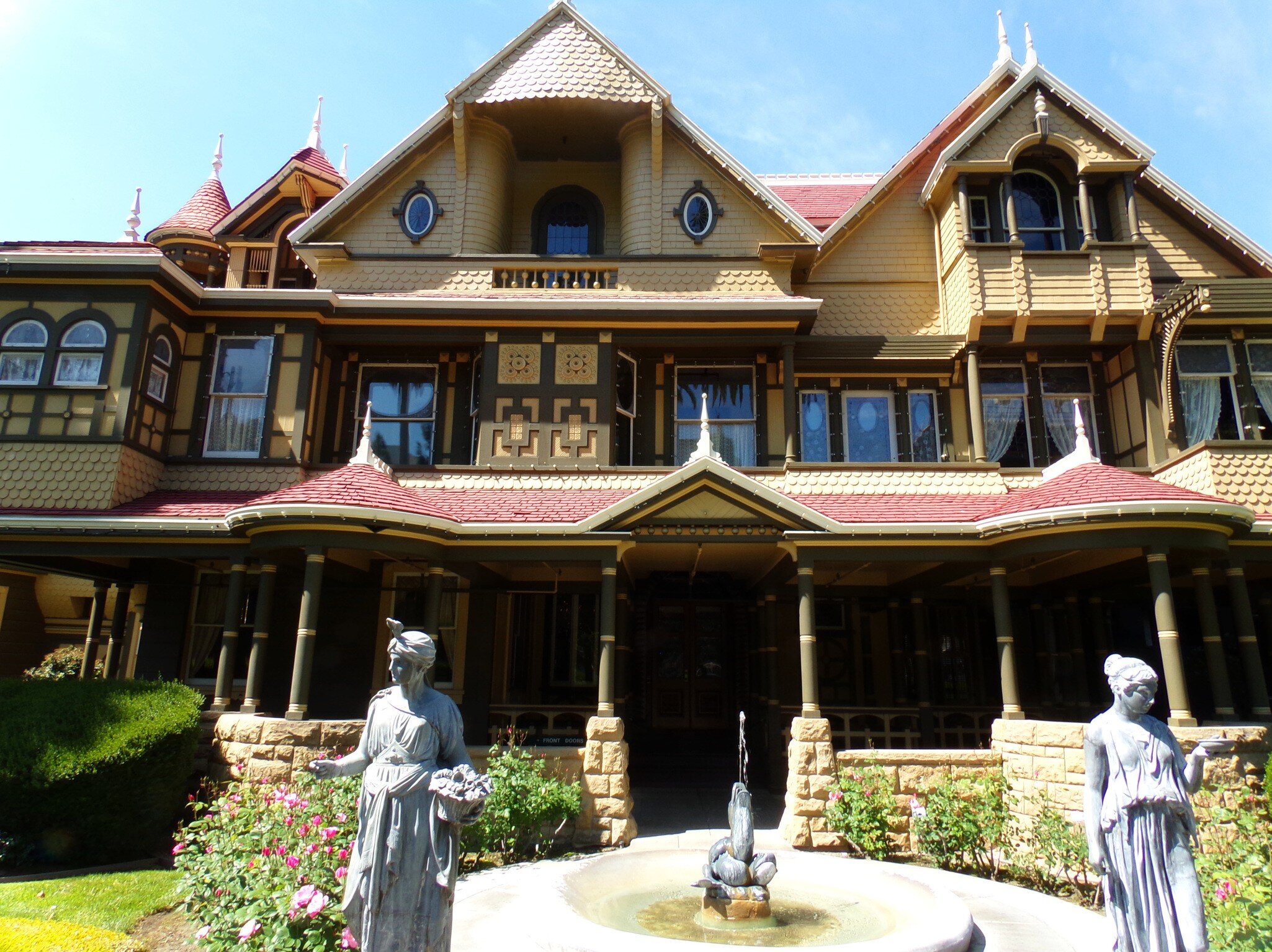 April 2, 2016: Exterior of the Winchester Mystery House with statues and a fountain.