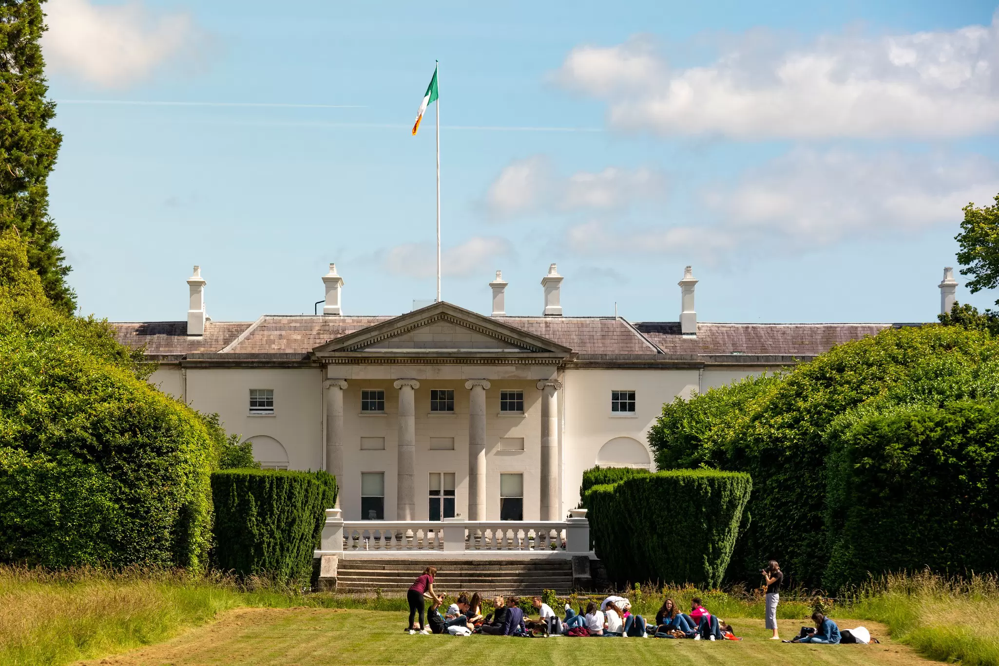 Students sitting in front of the official residence of the President of Ireland (Áras an Uachtaráin) located in Phoenix Park. Dublin, Ireland. 