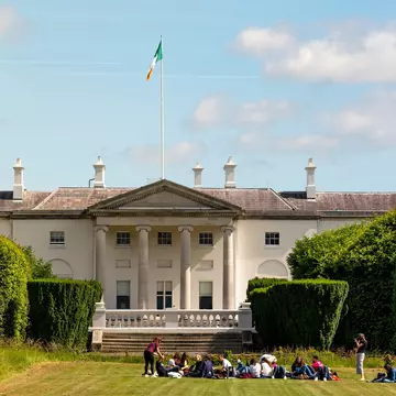 Students sitting in front of the official residence of the President of Ireland (Áras an Uachtaráin) located in Phoenix Park. Dublin, Ireland. 