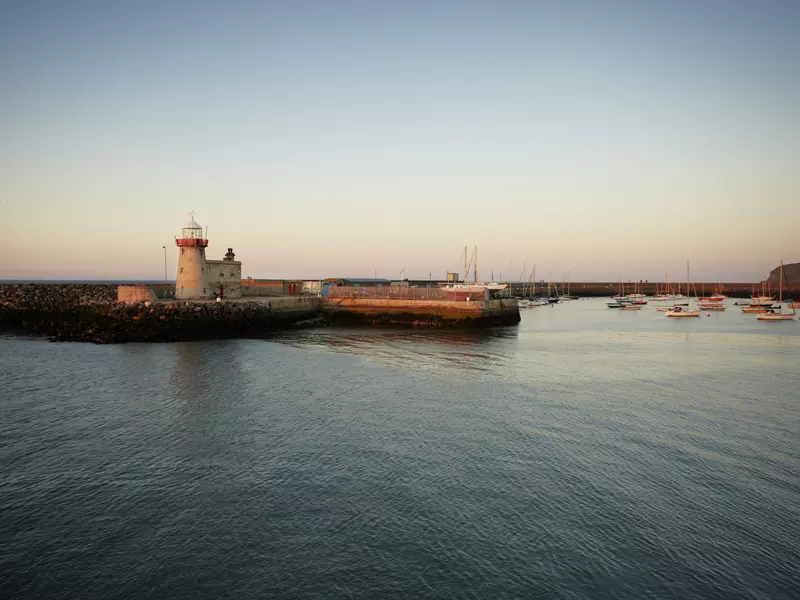 Lighthouse and fishing port at dusk.