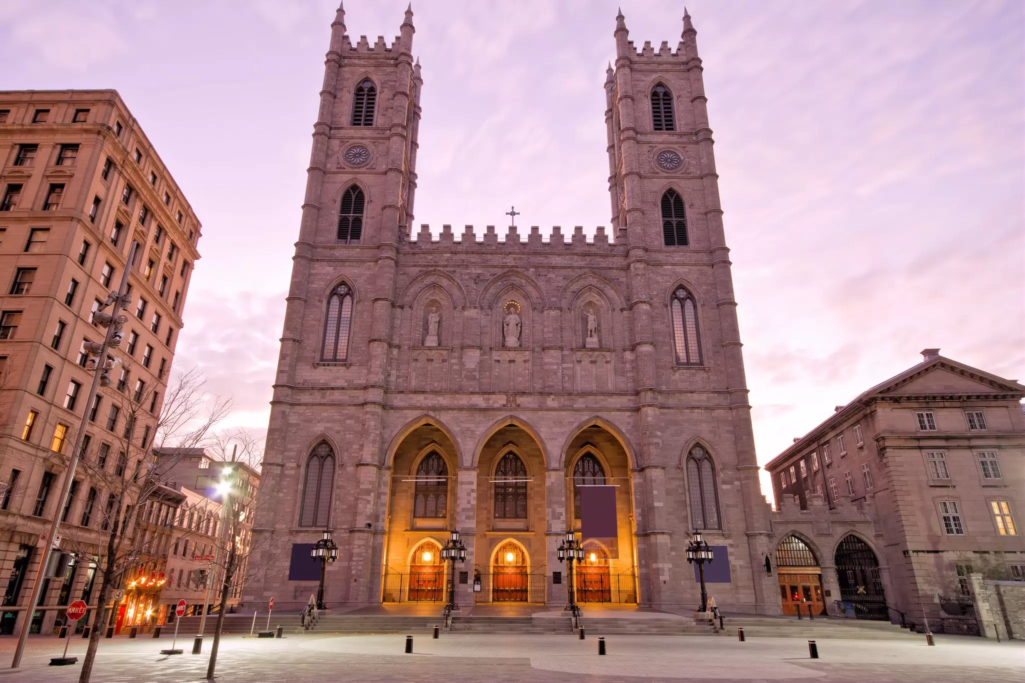 The exterior of a  Gothic twin-towered cathedral building on an empty city square