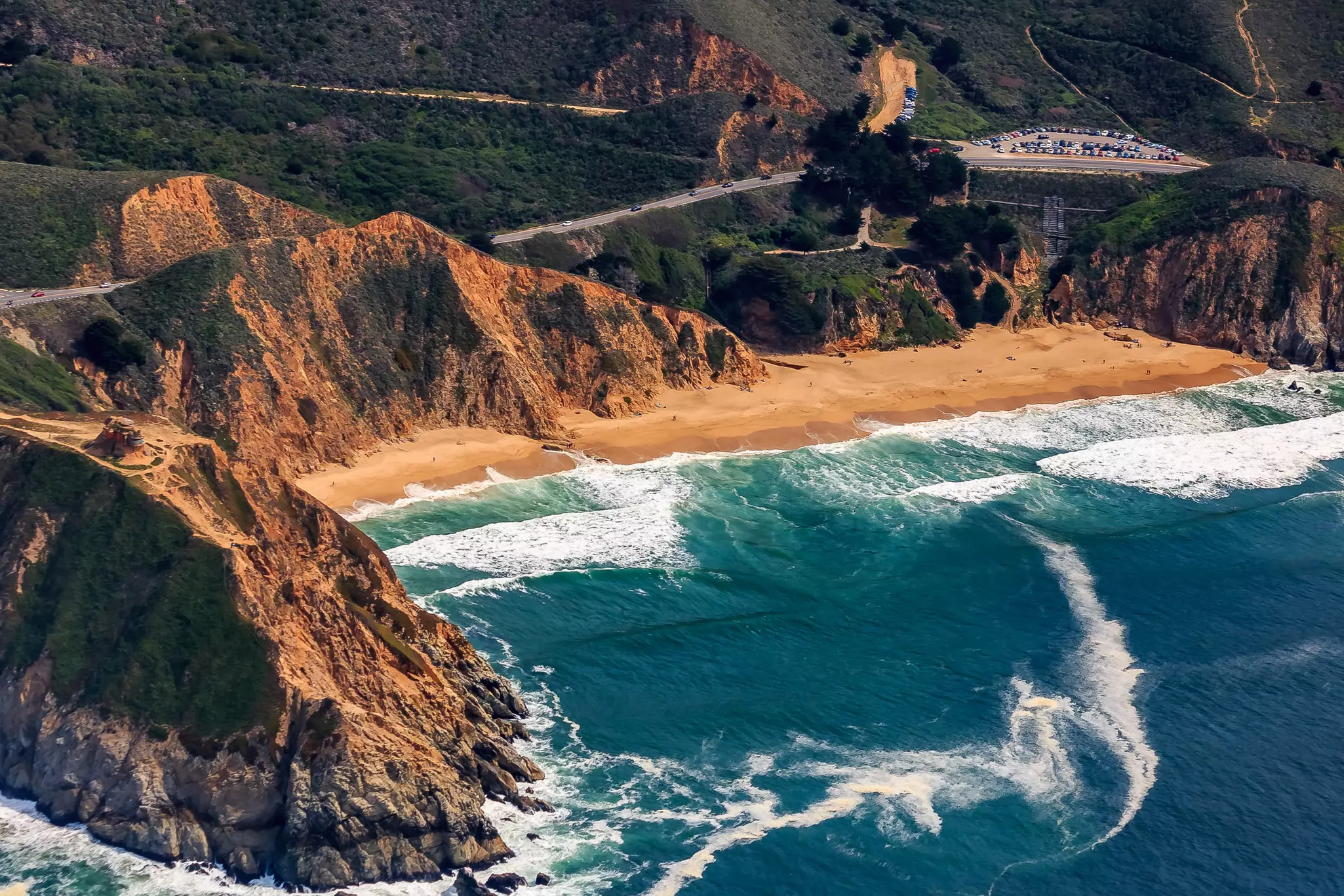 Rugged coastal cliffs by the Devil's Slide bunker and Gray Whale Beach in San Mateo County, Northern California, flying from San Francisco, USA