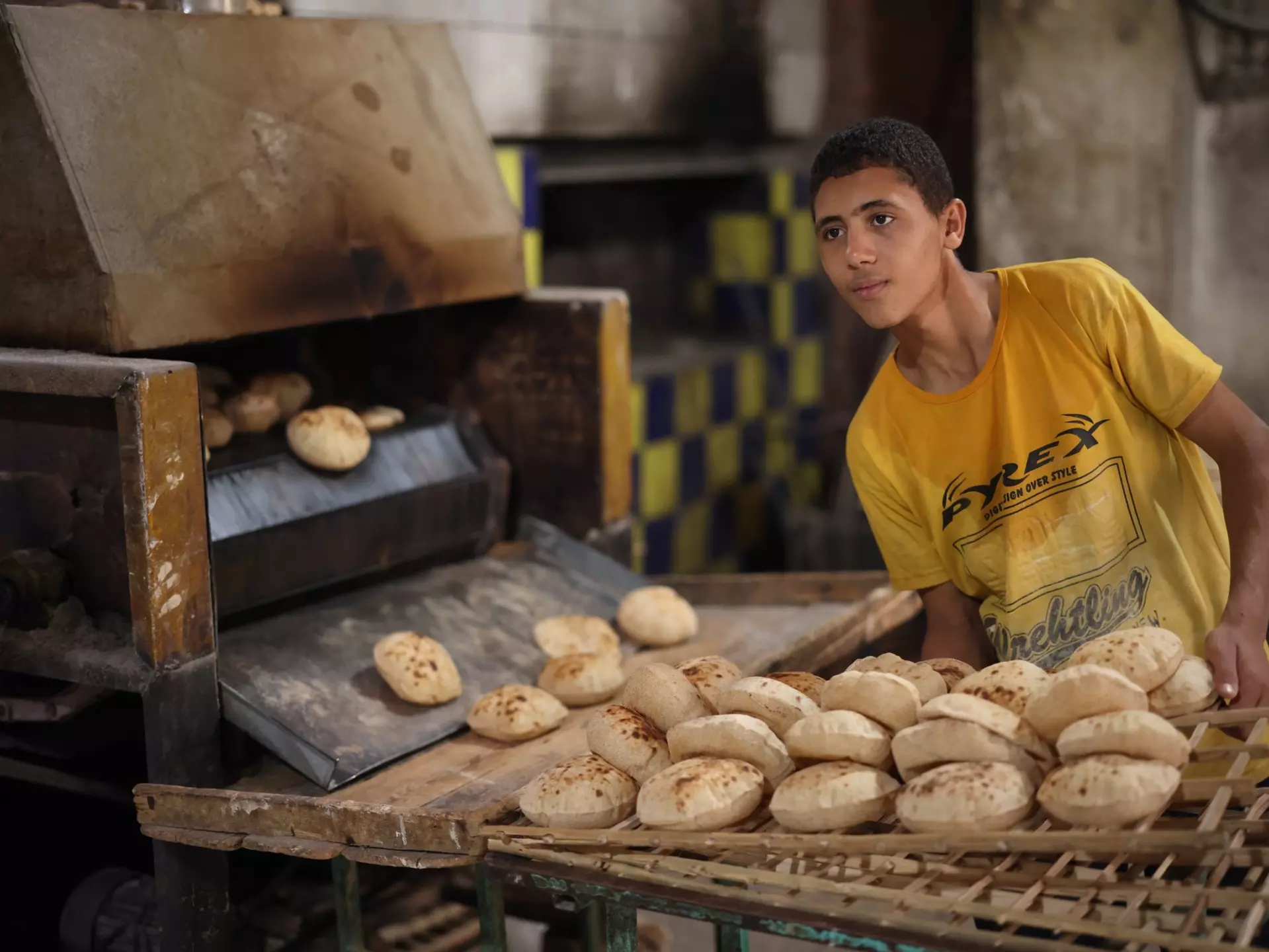 CAIRO, EGYPT - NOVEMBER 30, 2021: A young man works in a traditional bakery in Cairo, License Type: media, Download Time: 2025-11-10T11:23:43.000Z, User: joebindloss38, Editorial: true, purchase_order: 65050 - Digital Destinations and Articles, job: Online Editorial, client:  The best things to eat and drink in Egypt, other: Joe Bindloss