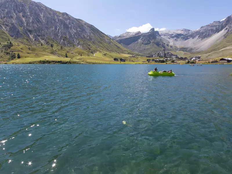 A paddle boat on an Alpine lake on a sunny day