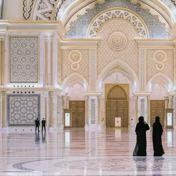 Abu Dhabi,UAE, March 2021.Two arabian local woman dressed traditional black visiting The Great Hall of new majestic Presidential Palace, Qasr Al Watan,with security guard team on blurred background., License Type: media, Download Time: 2025-11-26T15:13:44.000Z, User: clairenaylor, Editorial: true, purchase_order: 65050 - Digital Destinations and Articles, job: Online editorial, client: Abu Dhabi things to know, other: Claire Naylor