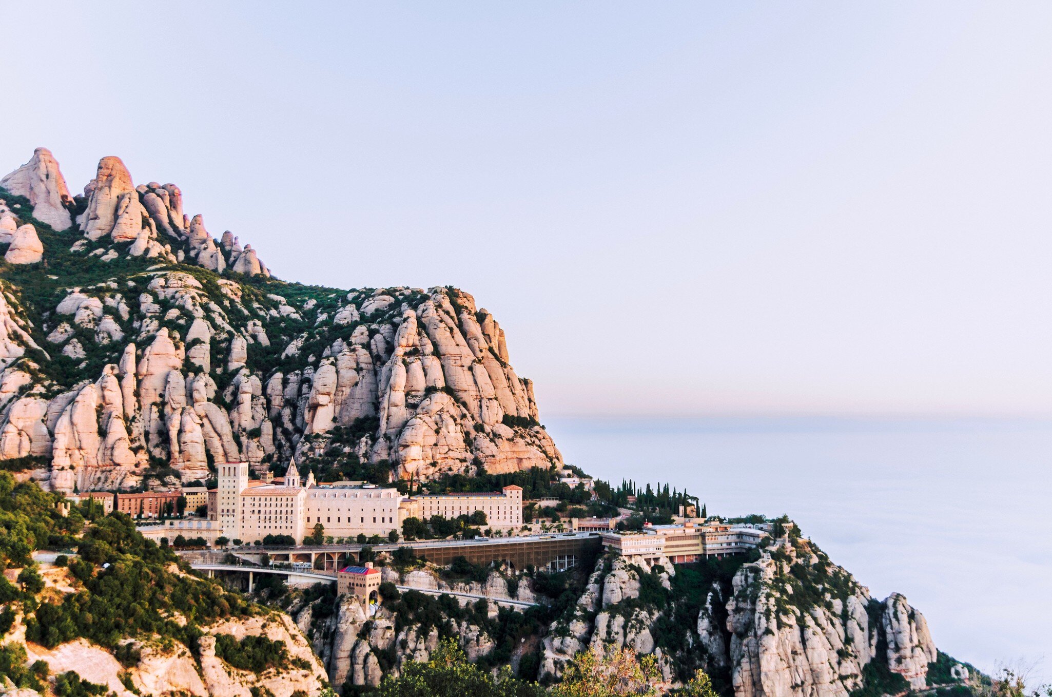 Montserrat, Spain - April 20, 2022:  View of Monserrat Monastery in the Mountains of Catalonia seen with visitors.
