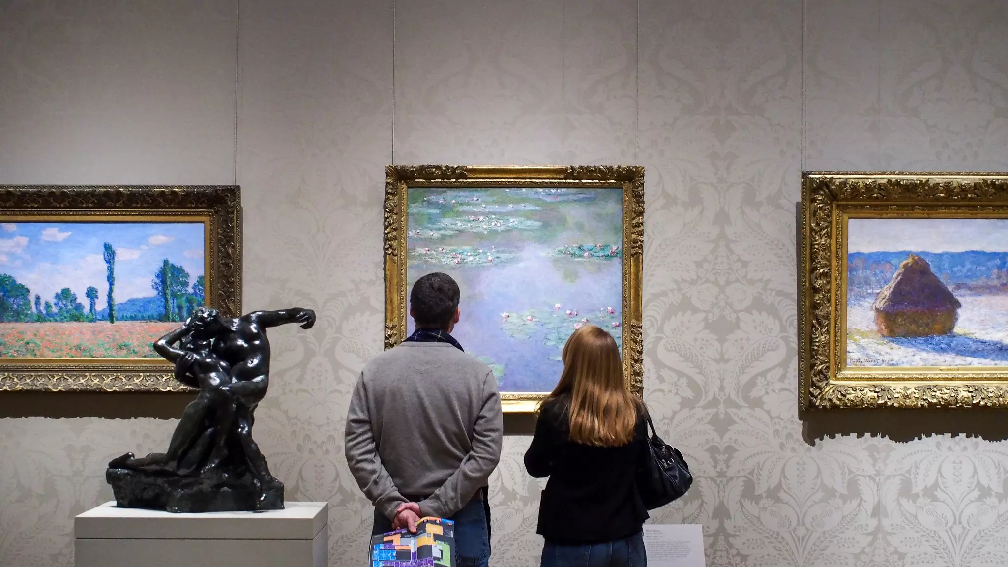 Visitors looking at Claude Monet's paintings at the Museum of Fine Arts in Boston.