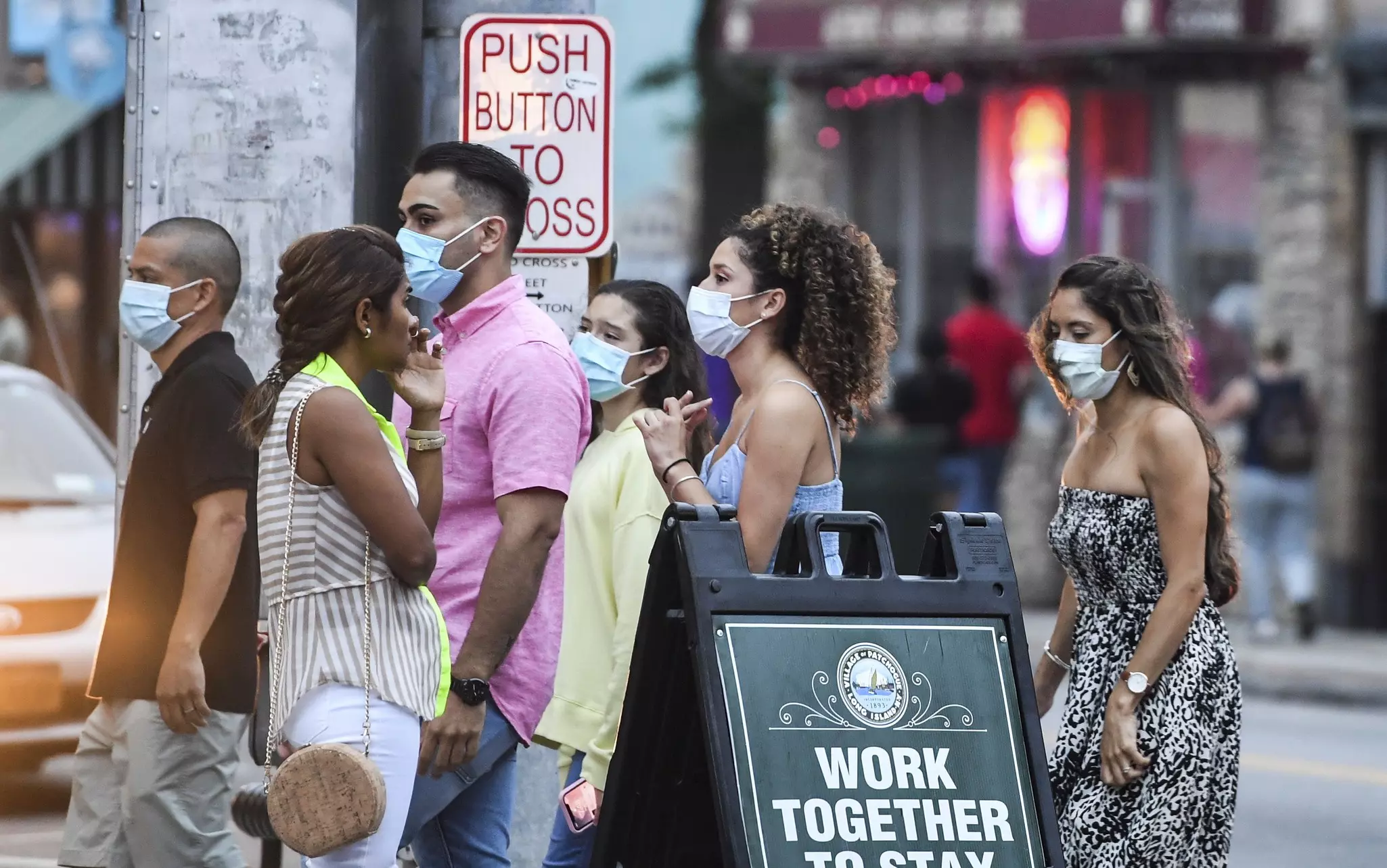 Young people wear masks while walking on Main Street in Patchogue on Long Island
