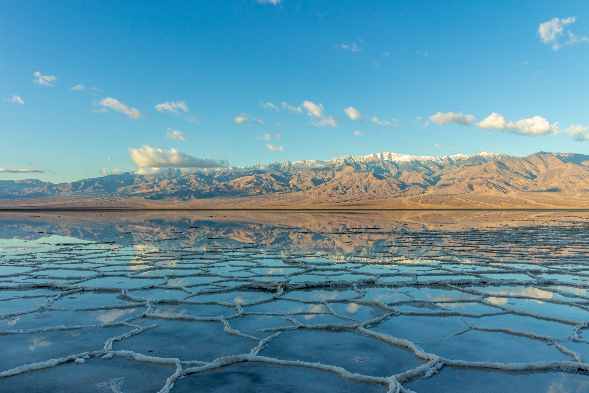 Badwater Basin and Telescope Peak with clouds reflected in the salt crust in Death Valley National Park. California.