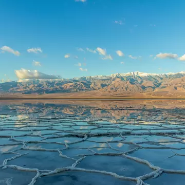 Badwater Basin and Telescope Peak with clouds reflected in the salt crust in Death Valley National Park. California.